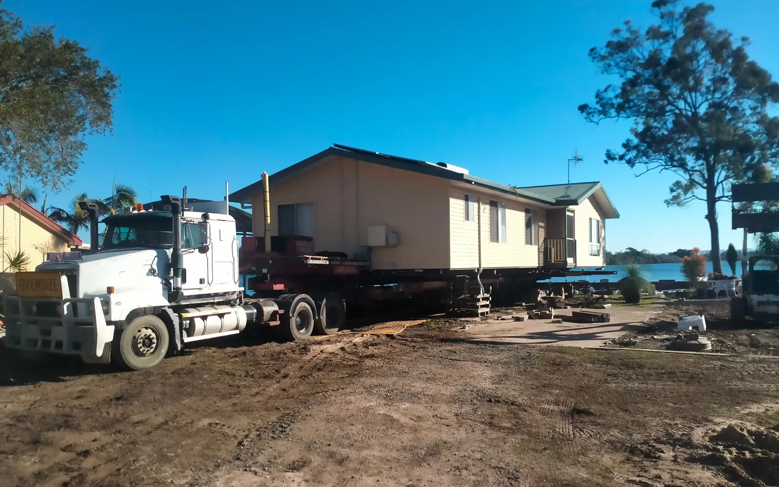 Mack truck ready to relocate a weatherboard house from a cleared hilltop block